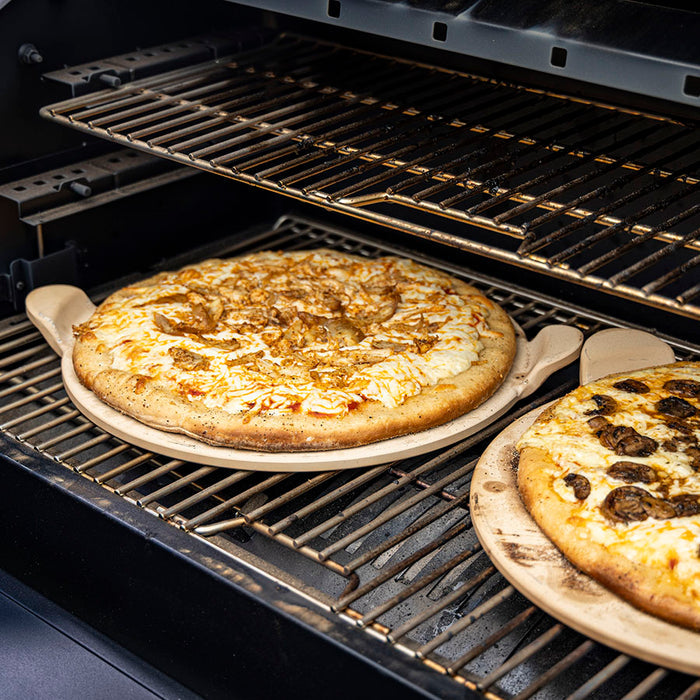 Pizza stone in grill with pizza on it. 15'' diameter.