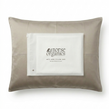 Norse Organics anti-acne bamboo pillowcase in natural beige with a branded product card resting on top