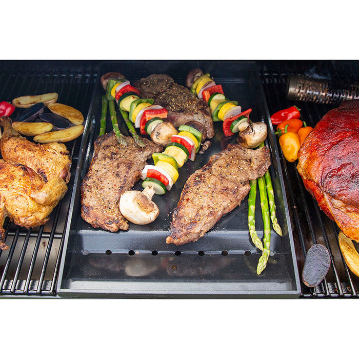Meats cooking on griddle insert and cooking gates. Close up. Smoke. Grill hood open.