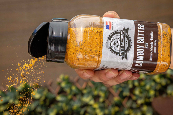 Hand sprinkling Pit Boss Cowboy Butter Rub onto food