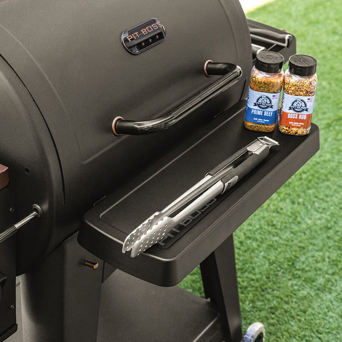 Black Pit Boss Grills 700 Series Onyx/DX front shelf with seasoning bottles and tongs.