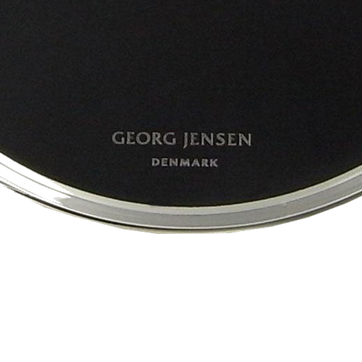 The Georg Jensen brand name is engraved at the bottom of these coasters.