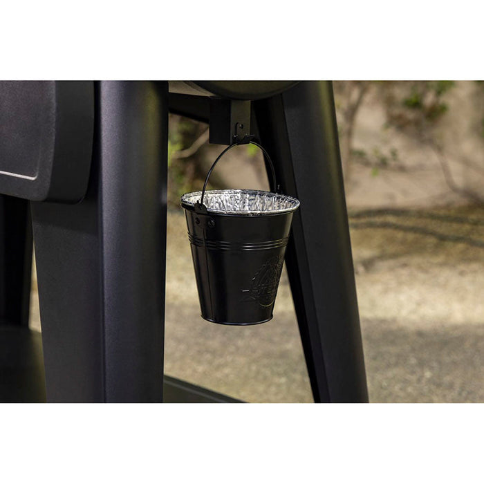 grease bucket hanging on grill will pan liner in it.