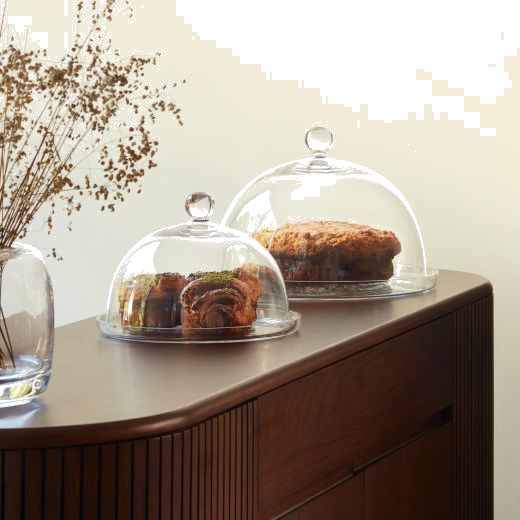 This Vienna Glass Dome and Plate 25 cm by LSA has a rounded dome shape with clear mouth-blown glass and a rounded handle.