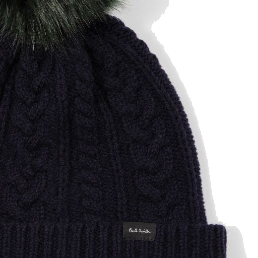 Paul Smith's Women's Navy Wool Cable Knit Pom-Pom Beanie Hat is made out of lambswool and a faux fur pom-pom on the top in dark green to contrast.