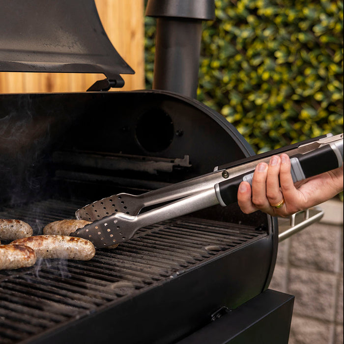 Pit Boss BBQ Tongs silver stainless still grilling sausages on wood pellet grill