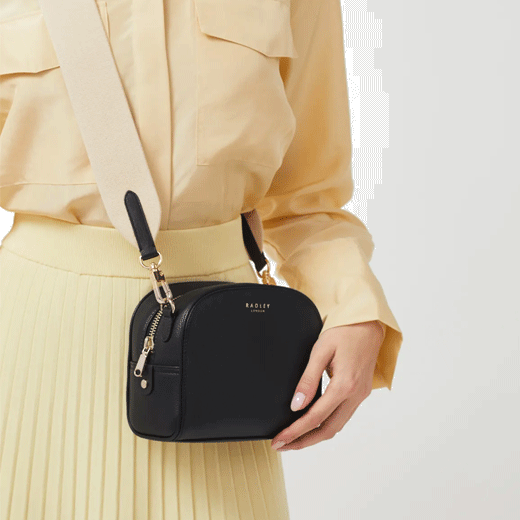 This Arden Crescent Black Cross Body Bag by Radley has a contrasting beige strap.