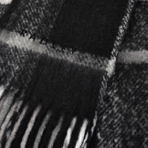 Radley's Fluffy Check Print Monochrome Scarf has a fringed edge that adds texture and is perfect for keeping warm during the Winter.