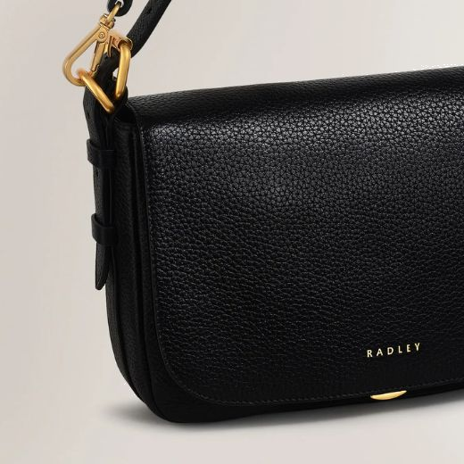 Radley's Graffton Street Black Small Flapover Cross Body Bag is made out of grained leather with a smooth finish and polished gold trims.