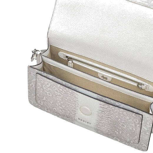 Inside the Leather Lane Bright White Faux Lizard Medium Flapover Shoulder Bag you will find a slip pocket, two spacious main compartments, and a zip pocket.