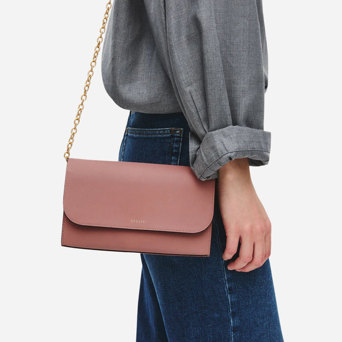 The Radley Lynton Road Carnation Leather Wallet On a Chain with chain strap attached.