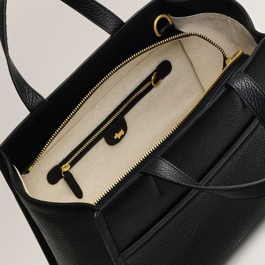 The interior of this Radley Oak Street Black Leather Zip-Top Medium Grab Bag has beige fabric lining with a zip pocket and slip pocket.