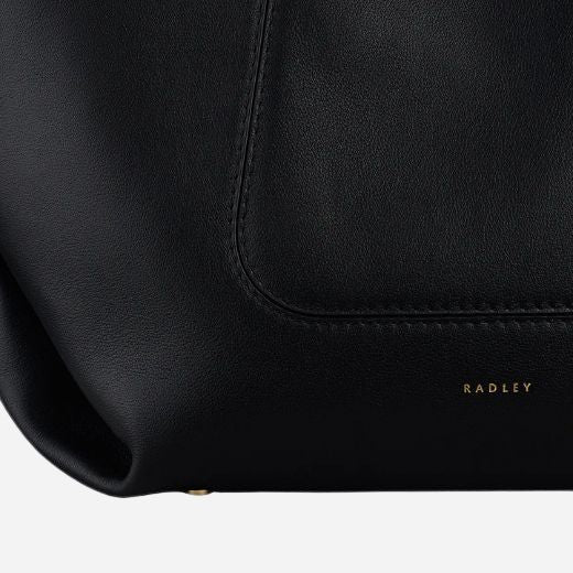 Corner view of The Compton Black Medium Zip Top Shoulder Bag.