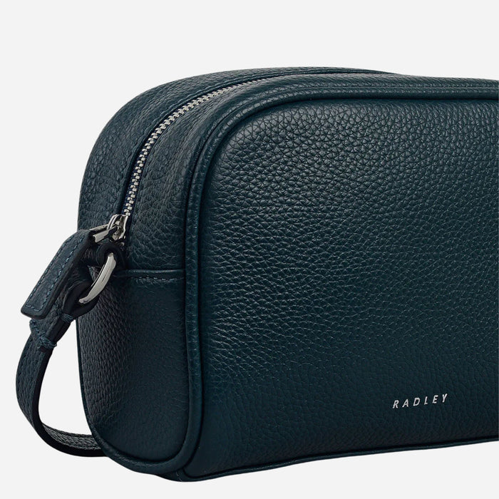 Side view of the Radley The Daily Teal Small Zip Top Cross Body Bag.