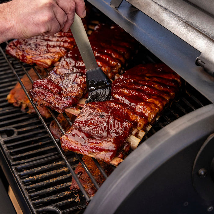 Pit Boss Grills BBQ Sauce Mop coating ribs with BBQ sauce on grill