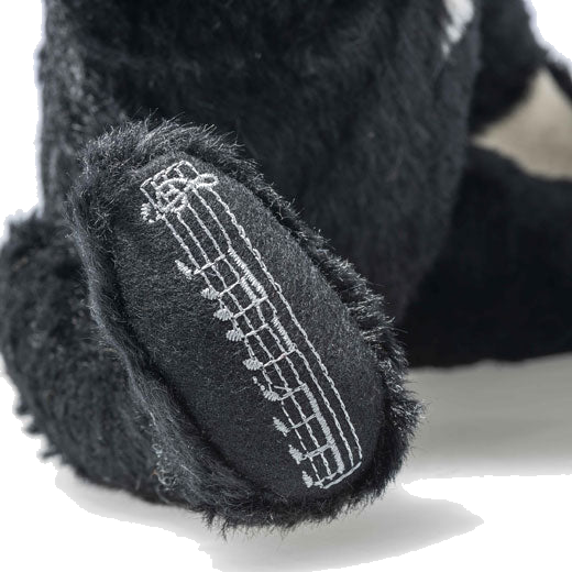 Steiff's James Bond Dr. No the Musical Teddy Bear features embroidery on the paw.