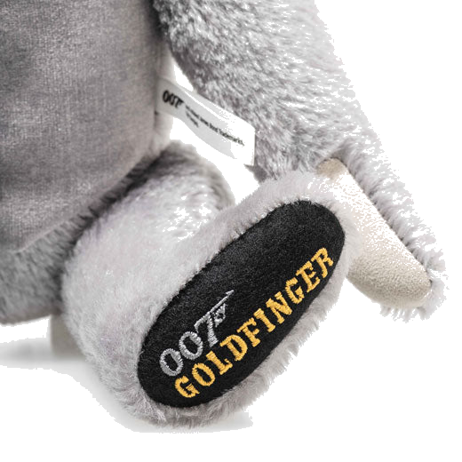 This James Bond Goldfinger 60th Anniversary Musical Teddy by Steiff has an embroidered paw with gold and grey.