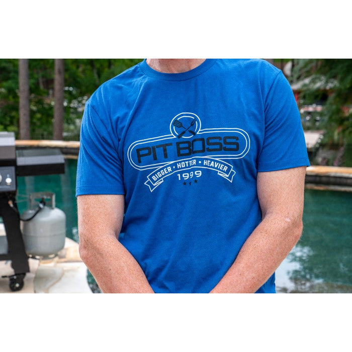 Royal Heather Pit Boss Grills men's t-shirt with "PIT BOSS" and "BIGGER • HOTTER • HEAVIER 1999" design.