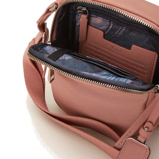 This Voyageur Dusty Pink Persia Cross Body Bag by TUMI has a contrasting marble print lining inside the main compartment and also has a card slot.